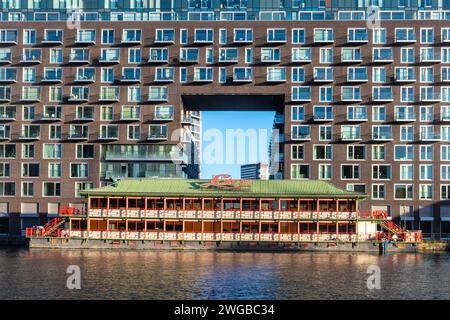 Das schwimmende Lotus Restaurant am Millwall Inner Dock auf der Isle of Dogs, London Docklands, England, Großbritannien, mit einem Wohnturm dahinter Stockfoto