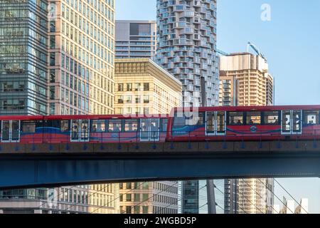 Die DLR Docklands Light Railway überquert die Brücke über das South Dock mit den Wolkenkratzern Canary Wharf in East London, England, Großbritannien Stockfoto
