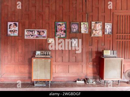 Inneneinrichtung des traditionellen thailändischen Holzhauses mit klassischer Stereo-hifi-anlage und Fotos thailändischer Berühmtheiten an der Wand. Stockfoto