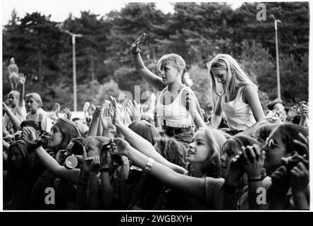 POP-FANS BRAVE THE REAIN, CARDIFF BIG WEEKEND1995: Junge Teenager Mädchen Popfans auf Schultern trotzen dem Sommerregen, um Boy Bands und Girl Bands bei der Red Dragon Roadshow beim Cardiff Big Weekend Festival auf den Museum Rwns in Cardiff, Wales, Großbritannien am 12. August 1995 zu sehen. Foto: Rob Watkins. INFO: Cardiff Big Weekend ist ein jährlich stattfindendes Musikfestival in Cardiff, Wales. Mit einer vielfältigen Auswahl an Künstlern zieht es Musikbegeisterte mit Live-Auftritten aus verschiedenen Genres an. Stockfoto