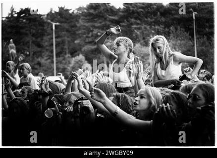 POP-FANS MUTEN DEN REGEN, CARDIFF BIG WEEKEND1995: Junge Teenager-Popfans auf Schultern trotzen dem Sommerregen, um Boy Bands und Girl Bands bei der Red Dragon Roadshow beim Cardiff Big Weekend Festival auf den Museum Rwns in Cardiff, Wales, Großbritannien am 12. August 1995 zu sehen. Foto: Rob Watkins. INFO: Cardiff Big Weekend ist ein jährlich stattfindendes Musikfestival in Cardiff, Wales. Mit einer vielfältigen Auswahl an Künstlern zieht es Musikbegeisterte mit Live-Auftritten aus verschiedenen Genres an. Stockfoto