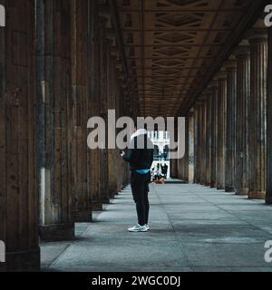 Mann auf dem Weg zwischen den Kolonnen in Berlin Stockfoto