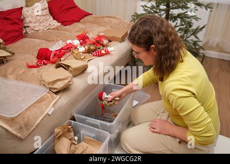 Die Weihnachtsbaumdekoration im Heim nach Weihnachten aufräumen. Vorbereitung auf die Neujahrsfeier und Auspacken der Einrichtung Stockfoto