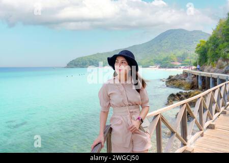 Junge asiatische Frau mit Hut genießt am tropischen Meer Strand an sonnigen Tag im Sommerurlaub Stockfoto