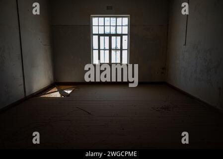 Kleines Fenster in einem Zimmer mit Fliesenboden und Holzfußboden Stockfoto