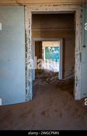 Eine offene Tür zeigt einen Raum mit Sandboden in einer alten, einsamen Stadt Stockfoto