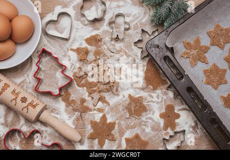 Direkt über dem Blick auf Keksteig, Küchenutensilien und Keksschneider für weihnachtskekse Stockfoto