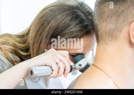 Arzt Dermatologe untersucht Haut und Muttermale des Patienten. Dermatoskopie, Melanomprophylaxe, Hautkrebs. Stockfoto