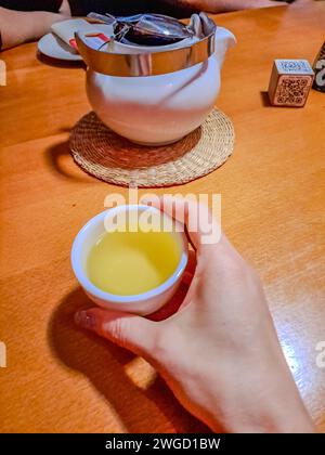 Teekonzept mit weißem Tee und Teekanne mit frischem Tee auf Holztisch Stockfoto