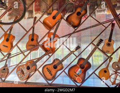 Alte Akustikgitarren hängen an der Wand in einem Landrestaurant Stockfoto