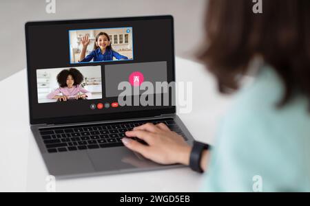 Junge Lehrerin mit Laptop mit Online-Unterrichtsbildschirm Stockfoto