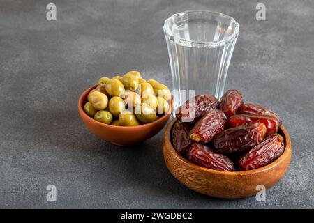 Traditioneller iftar-Tisch mit Datteln, grünen Oliven und einem Glas Wasser, Blick von oben Stockfoto