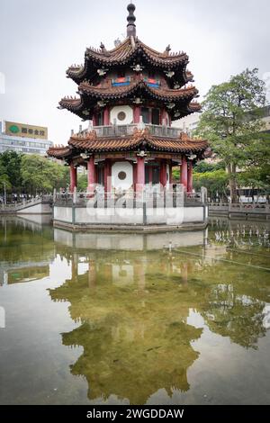 Kleiner asiatischer Tempel im Stadtpark reflektiert in einem Teich, vertikale Aufnahme, Taipeh, Taiwan Stockfoto