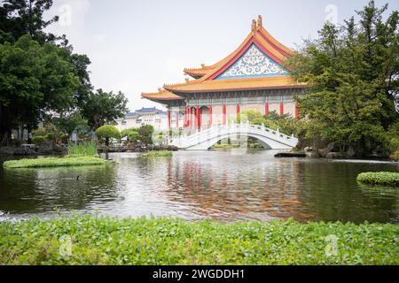 Wunderschöner asiatischer Garten mit Bonsais, Teich mit Brücke und majestätischem Tempel im Hintergrund, breit, Taiwan Stockfoto