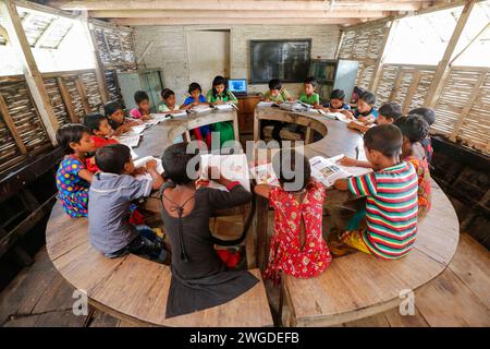 Dorfschüler besuchen eine Klasse an der Chalk Lanka Boat School. 2007 kam es zweimal zu Überschwemmungen, 332 Schulen wurden zerstört und 4.893 Schulen wurden beschädigt. Shidhulai betreibt eine Flotte schwimmender Schulen, Bibliotheken, Gesundheitskliniken, Solaranlagen und schwimmende Schulungszentren mit drahtlosem Internetzugang, die fast 97.000 Familien in wassergefährdeten Regionen bedienen. Boote selbst sind mit Solarpaneelen ausgestattet, die Computer, Leuchten und medizinische Geräte versorgen. Singra, Natore, Bangladesch. Stockfoto