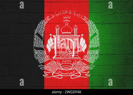 Afghanische Flagge auf einer Wand aus Schlackenblöcken gemalt. Stockfoto