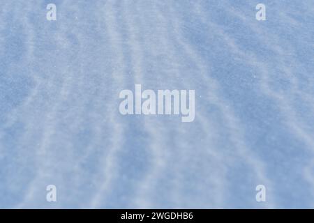 Schnee nach dem Wind bildet eine weiße Leinwand aus wirbelnden Mustern. Leicht, funkelnd, mit Eiskristallen. Eine einzigartige natürliche Textur und die Ruhe des Th Stockfoto