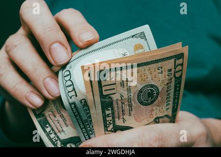 Nahaufnahme amerikanischer Dollars in Händen, Banknoten zählen, Vintage-Ton. Konzept der Finanzierung, des Geschäfts, des Einkommens. Stockfoto