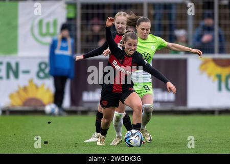 Kampf um den Ball zwischen Caroline Siems (Bayer 04 Leverkusen, #13), Ewa Pajor (VfL Wolfsburg, #09) und Kristin Koegel (Bayer 04 Leverkusen, #11). Fussball: Google Pixel Frauen-Bundesliga, Saison 2023/2024, 12. Spieltag, Bayer 04 Leverkusen - VfL Wolfsburg am 04.02.2024 im Ulrich-Haberland-Stadion in Leverkusen. Wichtiger Hinweis: Gemaess den Vorgaben der DFL Deutsche Fussball Liga bzw. Des DFB Deutscher Fussball-Bund ist es untersagt, in dem Stadion und/oder vom Spiel angefertigte Fotoaufnahmen in Form von Sequenzbildern und/oder videoaehnlichen Fotostrecken zu verwerten bzw. Verwerten zu la Stockfoto