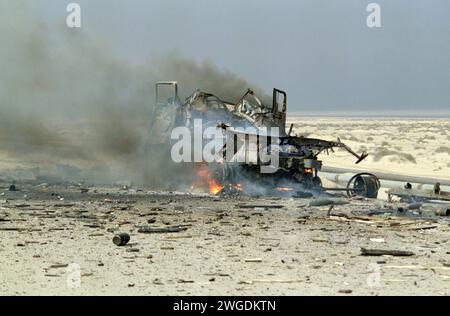 Erster Golfkrieg: 4. März 1991 nicht explodierte Artilleriegranaten verstreuen die Straße um einen brennenden irakischen Lastwagen, der von der USAF im Nordosten Kuwaits bombardiert wurde. Stockfoto