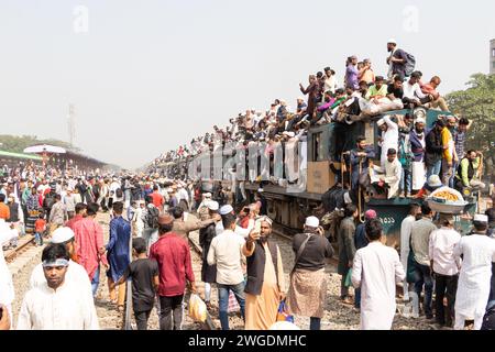 Tongi, Dhaka, Bangladesch. Februar 2024. Muslimische Gläubige reisen mit überfüllten, riskanten Zügen, nachdem sie das Akheri Munajat (letztes Gebet) im Biswa Ijtema in Tongi, Dhaka, Bangladesch besucht haben. Die Einheimischen nehmen die Reise in Angriff, indem sie auf den Dächern der Lokomotiven klettern, sich daran festhalten und entlang klettern. Da im Inneren keine Sitzplätze verfügbar sind, entscheiden sich viele Pendler, das Risiko einzugehen und einen Blick von der Dachterrasse für ihre Reise aus Dhaka zu wählen. Quelle: ZUMA Press, Inc./Alamy Live News Stockfoto