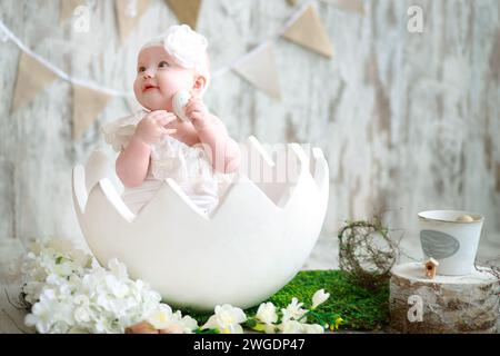 Baby in einem großen Osterei. Osterdekor. Stockfoto