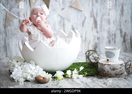 Baby in einem großen Osterei. Osterdekor. Stockfoto