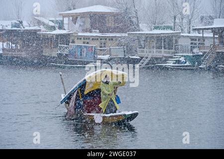 Srinagar, Indien. Februar 2024. SRINAGAR, INDIEN – 4. FEBRUAR: Ein Bootsmann überquert den Dal-See während eines Schneefalls am 4. Februar 2024 in Srinagar, Indien. Mehrere Teile Kaschmirs, darunter auch die Stadt Srinagar, waren Zeugen von Neuschneefall, da das Met-Departement in den nächsten 48 Stunden mittelschwere oberste Schneefälle im Tal prognostiziert hat. (Foto: Waseem Andrabi/Hindustan Times/SIPA USA) Credit: SIPA USA/Alamy Live News Stockfoto