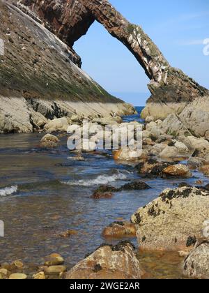 Reisen Sie entlang der Küstenstraße von Moray: Bow Fiddle Rock ist ein dramatischer natürlicher Meeresbogen, der durch Wellenbewegung und Erosion geformt wurde und an die Bogenspitze einer Geige erinnert. Stockfoto