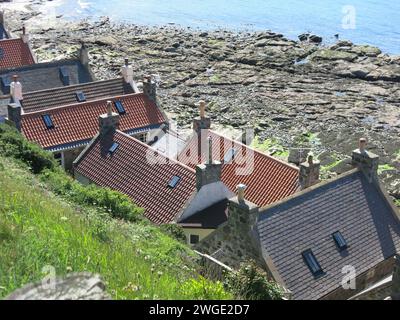 Malerisches und abgelegenes NE Schottland: Die ehemaligen Fischerhütten Klammern sich am Fuß der Klippen vor der felsigen Nordseeküste bei Crovie. Stockfoto