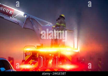 RICHMOND, BC, KANADA - 27. JULI 2023: Richmond Feuerwehrleute und Löschfahrzeuge bekämpfen ein tosendes Feuer, Rettungsdienste, Ersthelfer, Rauch, Wasser Stockfoto