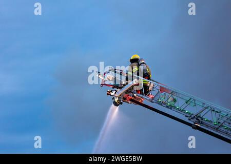 RICHMOND, BC, KANADA - 27. JULI 2023: Richmond Feuerwehrleute und Löschfahrzeuge bekämpfen ein tosendes Feuer, Rettungsdienste, Ersthelfer, Rauch, Wasser Stockfoto