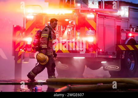 RICHMOND, BC, KANADA - 27. JULI 2023: Richmond Feuerwehrleute und Löschfahrzeuge bekämpfen ein tosendes Feuer, Rettungsdienste, Ersthelfer, Rauch, Wasser Stockfoto