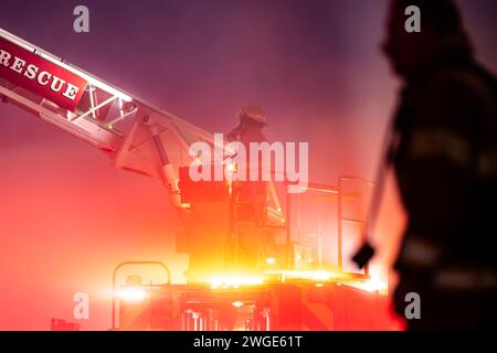 RICHMOND, BC, KANADA - 27. JULI 2023: Richmond Feuerwehrleute und Löschfahrzeuge bekämpfen ein tosendes Feuer, Rettungsdienste, Ersthelfer, Rauch, Wasser Stockfoto