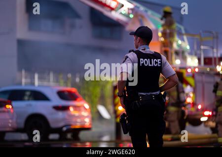 RICHMOND, BC, KANADA - 27. JULI 2023: Richmond Feuerwehrleute und Löschfahrzeuge bekämpfen ein tosendes Feuer, Rettungsdienste, Ersthelfer, Rauch, Wasser Stockfoto