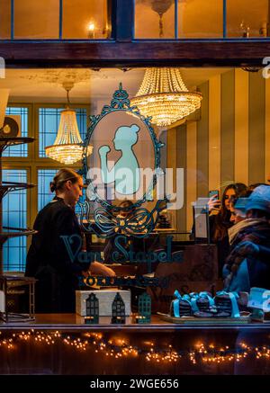 Amsterdam, Niederlande, 20. November 2022. Blick auf ein Fenster des berühmten Keksladens Van Stapele Koekmakerij mit Personal, das Gäste bedient. Stockfoto