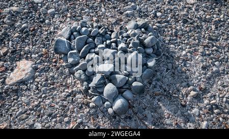 Am Strand werden große Steine zu einer Herzform gemacht. Stockfoto
