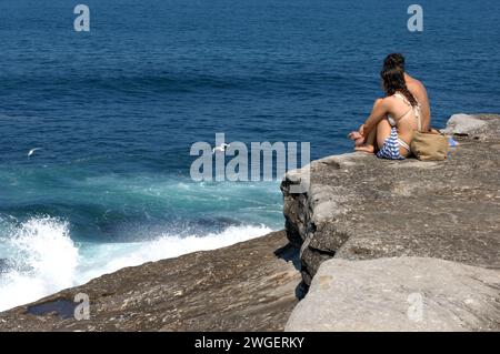 Die Besucher genießen die dramatischen Felsformationen im Rahmen des Coogee to Bondi Walk in Sydney, Australien. Stockfoto