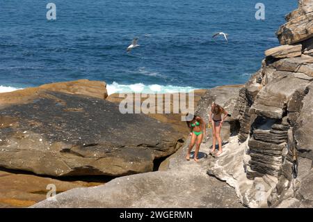 Die Besucher genießen die dramatischen Felsformationen im Rahmen des Coogee to Bondi Walk in Sydney, Australien. Stockfoto