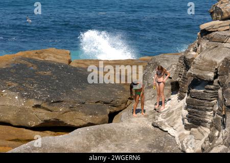 Die Besucher genießen die dramatischen Felsformationen im Rahmen des Coogee to Bondi Walk in Sydney, Australien. Stockfoto