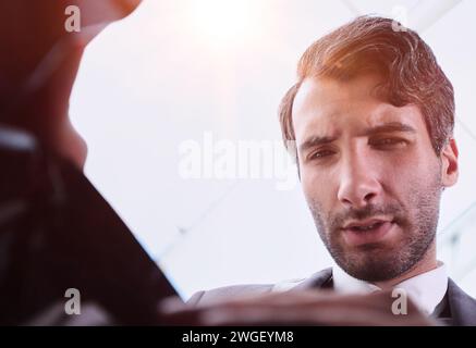 Ein Geschäftsmann nimmt einen Ordner aus einer Plastiktüte. Ansicht von unten Stockfoto