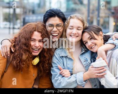 Gruppe junger Teenager, die Spaß beim Umarmen in einer Stadt haben. Das Konzept von Kameradschaft und Einheit Stockfoto