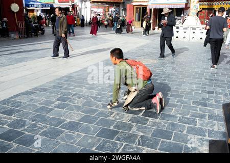 Ein Mann kniet vor Buddha in der Bakhor Street in Lhasa nieder. Stockfoto