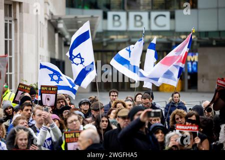 London, Großbritannien. Februar 2024. Während einer Kundgebung vor dem BBC-Hauptquartier hält eine Menge Demonstranten israelische Fahnen. Israelische Unterstützer versammeln sich im Hauptquartier der BBC zu einer Kundgebung, um einen fairen Bericht über den Israel-Hamas-Krieg zu fordern und die Hamas-Streitkräfte zur Freilassung der restlichen Geiseln im Gaza-Streifen zu drängen. Der Konflikt brach im Nahen Osten aus, nachdem Hamas-Truppen am 7. Oktober 2023 eine örtliche Gemeinde in Südisrael überfallen und mehr als 200 Geiseln gefangen genommen und Hunderte weitere getötet hatten. Quelle: SOPA Images Limited/Alamy Live News Stockfoto