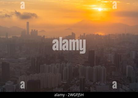 Eine majestätische urbane Metropole entlang der Küste, umgeben von malerischen Hügeln in Hongkong während des Sonnenuntergangs Stockfoto