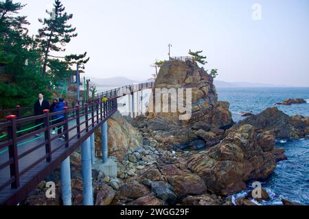 Samcheok City, Südkorea - 28. Dezember 2023: Ein Blick auf den Chogok Yonggul Cave Wander Trail, mit einem Wanderdeck im Vordergrund, einem hohen Felsen Stockfoto