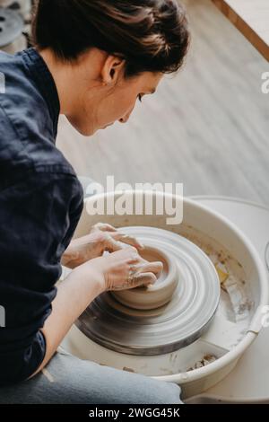 Eine Frau in einer Töpferwerkstatt arbeitet an einem Töpferrad Stockfoto