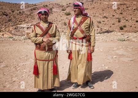 Zwei jordanische Polizeibeamte patrouillieren die UNESCO-Stätte. Petra ist eine historische und archäologische Stadt im Süden Jordaniens. Petra ist berühmt für seine Felsenarchitektur und das Wasserleitungssystem und wird wegen der Farbe des Sandsteins, aus dem es geschnitzt ist, auch „Rosenstadt“ genannt. Es grenzt an den Berg Jabal Al-Madbah, in einem Becken, das von Bergen umgeben ist, die die Ostflanke des Arabah-Tals bilden, das vom Toten Meer bis zum Golf von Aqaba verläuft. Der Zugang zur Stadt erfolgt über eine berühmte malerische Schlucht namens Siq, die direkt zum Khazneh führt. Jordon. Stockfoto