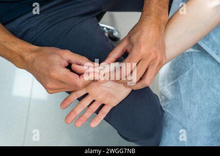 Nahaufnahme der Hände, die eine Massage auf einer Handfläche durchführen Stockfoto