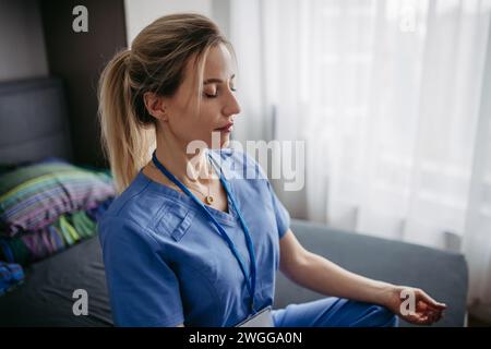 Nahaufnahme der Krankenschwester oder des Arztes, die nach der Arbeit Freizeit zu Hause genießen, Meditieren. Work-Life-Balance für eine Pflegekraft. Stockfoto